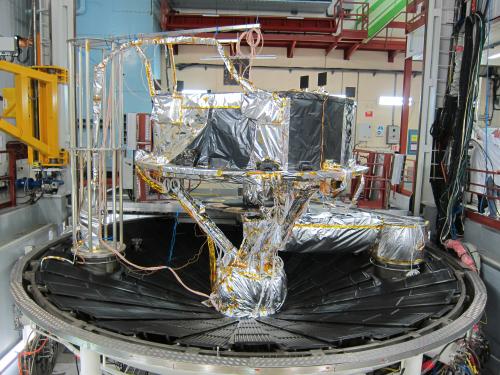 Gaia Service Module (SVM) ready for thermal balance/thermal vacuum testing in the SIMLES chamber at Intespace Toulouse. The SVM is mounted on a tripod; the gantry on the left carries instrumentation cables to one of the interfaces on the base of the chamber. Underneath the SVM, the Phased Array Antenna (PAA) test heater and the bundle of test cables coming from the various temperature sensors, test heaters and from the PAA RF test ports can be seen. This large bundle of PAA cables is covered by Multi-Layer Insulation (MLI) to control its temperature and can be seen on the picture as a silver cylinder going to the right and then through the bottom floor of the chamber. ***** 22 July 2012 ***** credits: Astrium SAS